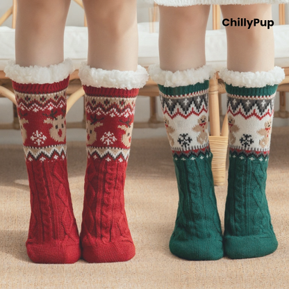 Three pairs of festive cable-knit socks with white faux-fur trim are shown on feet. The left pair is red with a cream and red holiday pattern; the center pair is cream with a red and green pattern; the right pair is dark green with a red and cream pattern.