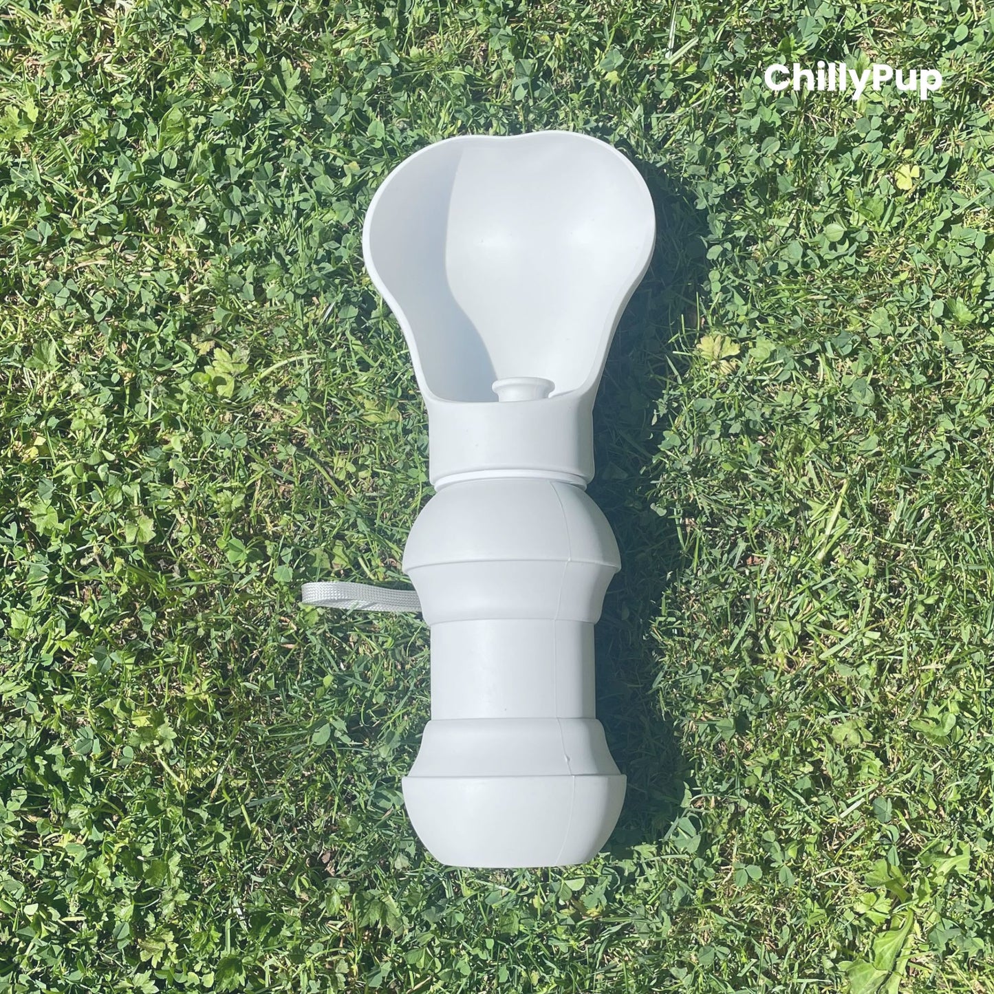 One foldable silicone water bottle with drinking section on grass.